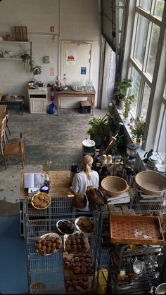 a woman sitting at a table in a room full of food