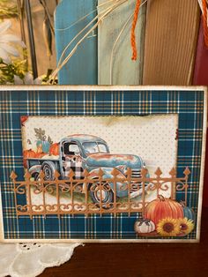 an old fashioned blue truck with pumpkins on the front and sides is framed by a wooden fence