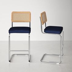 two chairs sitting next to each other on top of a white floor and one has a blue seat