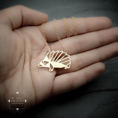 Adorable gold origami hedgehog pendant, featuring our original cutout design of a hedgehog body. This fun necklace is Perfect for any occasion the necklace will add chic to any outfit you choose. ★ Comes in our signature gift box, ready for gift giving. ★ Available in Gold [18k gold-filled chain & 18k gold plated brass ... Origami Hedgehog, Hedgehog Necklace, Silver Hedgehog, Origami Necklace, Jewelry Design Studio, Egyptian Necklace, Origami Jewelry, A Hedgehog, Outfit Chic