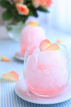 two glasses filled with pink liquid on top of a blue and white striped table cloth