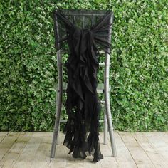 a chair that is sitting in front of a wall covered with green plants and ivy