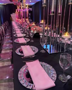 the table is set with pink napkins and place settings for an elegant dinner party