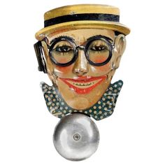 a ceramic head with glasses and a hat on it's head is hanging from a hook