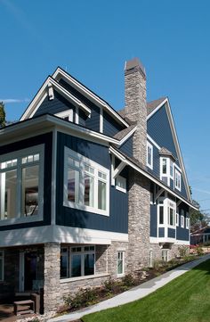 a blue house with white trim on the front and side windows is shown in this photo