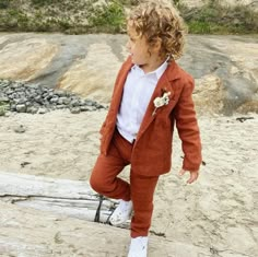 a little boy in an orange suit and white shirt