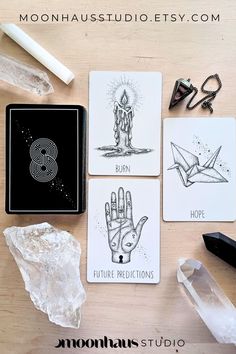 four cards with different designs on them sitting next to some crystals and other items that include scissors