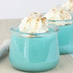 two small jars filled with whipped cream on top of a table