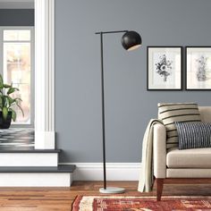 a living room scene with focus on the couch and floor lamp in the foreground