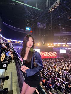 a woman standing in front of an audience at a sporting event holding a toothbrush