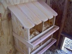 a bird house made out of wood and some birdseed in the nest box next to it