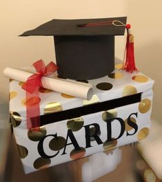 a graduation cap and diploma sitting on top of a gift wrapped in polka dot paper