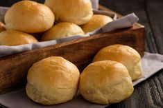 some bread rolls are in a wooden box