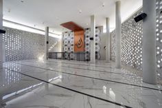 the inside of a building with white marble flooring and decorative wall panels on the walls