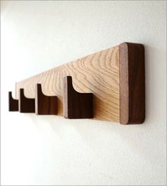 three wooden pegs mounted to the side of a wall