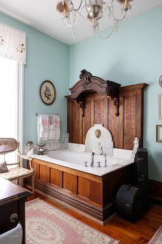 an old fashioned bathtub in the corner of a room with blue walls and wood paneling