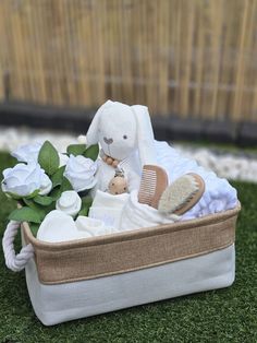 a stuffed animal sitting in a basket on top of green grass next to white flowers