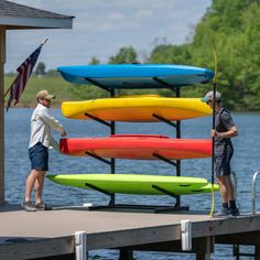 two men are standing on a dock with surfboards in front of them and an american flag