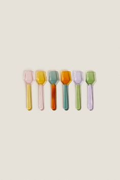 five different colored glass utensils lined up in a row