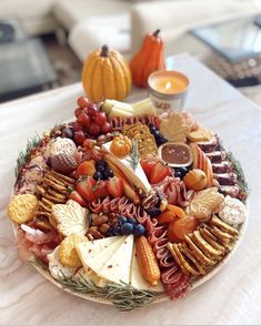 a platter filled with different types of cheese and crackers on top of a table