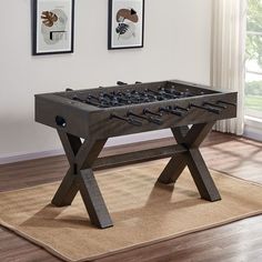 a foosball table sitting on top of a rug in front of a window