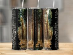 two black and white canisters with trees on them sitting on a wooden table