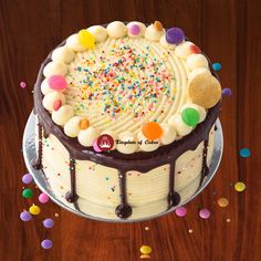 a cake with white frosting and colorful sprinkles