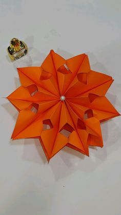 an orange origami flower sitting on top of a table