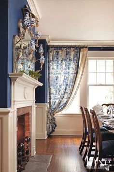 a dining room with blue walls and wood flooring, along with a fireplace mantel