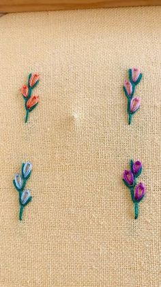 four embroidered flowers on a piece of fabric