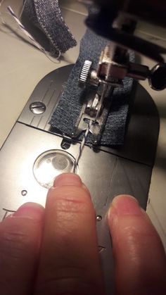 someone is sewing something on a machine with their fingers and the needle has been sewn