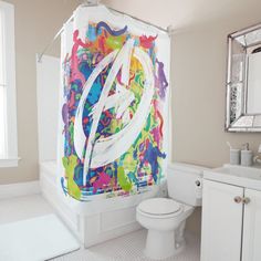 a bathroom with a shower curtain that has graffiti on it