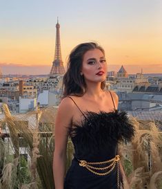 a woman standing in front of the eiffel tower with her hands on her hips