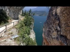 a road going up the side of a cliff next to a body of water