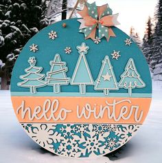 a wooden sign that says hello winter with snowflakes and trees in the background