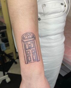 a person with a small tattoo on their arm that has a doctor who is in the doorway