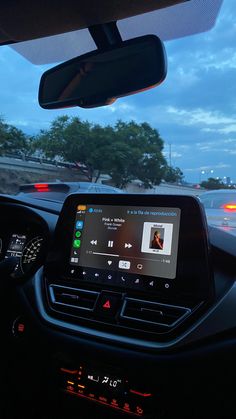 the dashboard of a car with an electronic device in it's center console at night