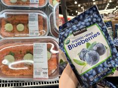 blueberries and cucumbers are in plastic containers on display at a grocery store