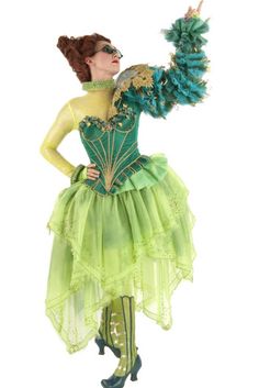 a woman dressed in green and yellow holding a fan