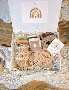 an open gift box filled with assorted items on a lace tablecloth covered table