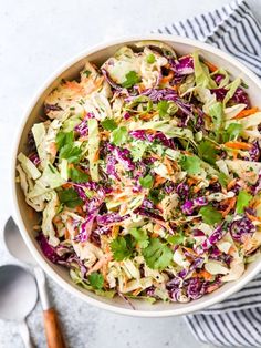 a white bowl filled with coleslaw on top of a blue and white towel