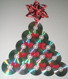 a christmas tree made out of cd's with red bows on the top and silver discs around it