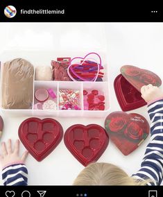 a child is playing with heart shaped boxes