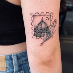 a woman's arm with a stamp on it that has an image of a building