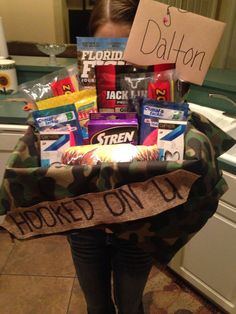 a woman holding a basket full of snacks and candy in her hands with a sign that says, i'm bored on it