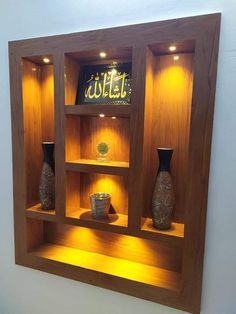 a wooden shelf with some vases on top of it and lights in the middle