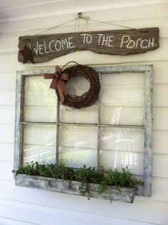 an old window with a welcome to the porch sign hanging on it's side