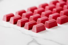 several pieces of red candy sitting on top of a white counter