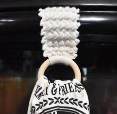 a knitted bag with a wooden ring hanging from it