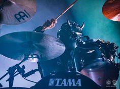 a man playing drums in front of a drum set